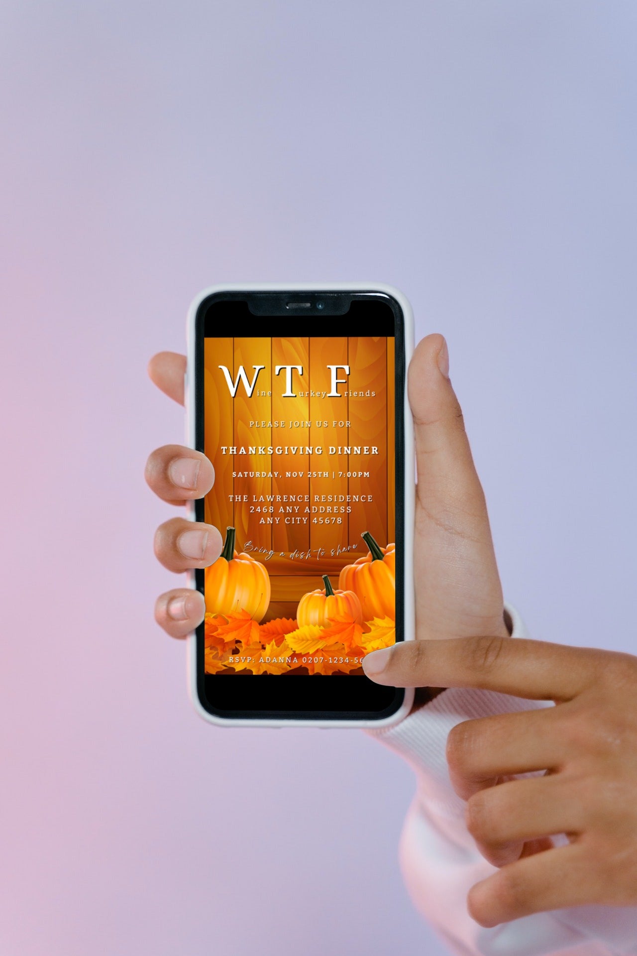 Hand holding a smartphone displaying the Yellow Wood Pumpkin Leaves | WTF Thanksgiving Evite template from URCordiallyInvited.