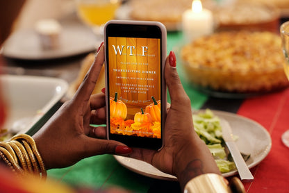 Person holding a phone displaying the Yellow Wood Pumpkin Leaves | WTF Thanksgiving Evite template, ready for customization in Canva.