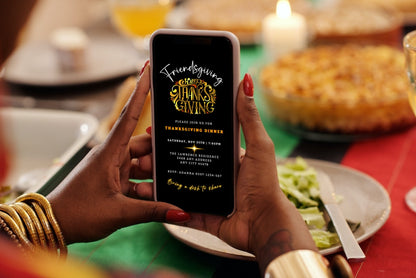 Person holding a phone displaying the Gold Red Neon Black | Friendsgiving Thanksgiving Evite template, customizable via Canva for electronic invitations.