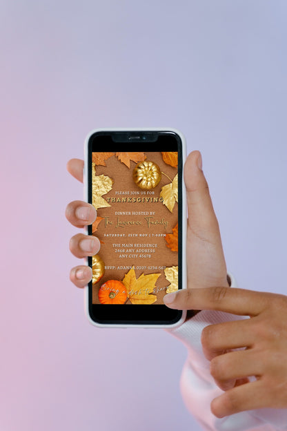 Hand holding a smartphone displaying the Beige Gold Leaves Pumpkin | Thanksgiving Evite template for customization in Canva.