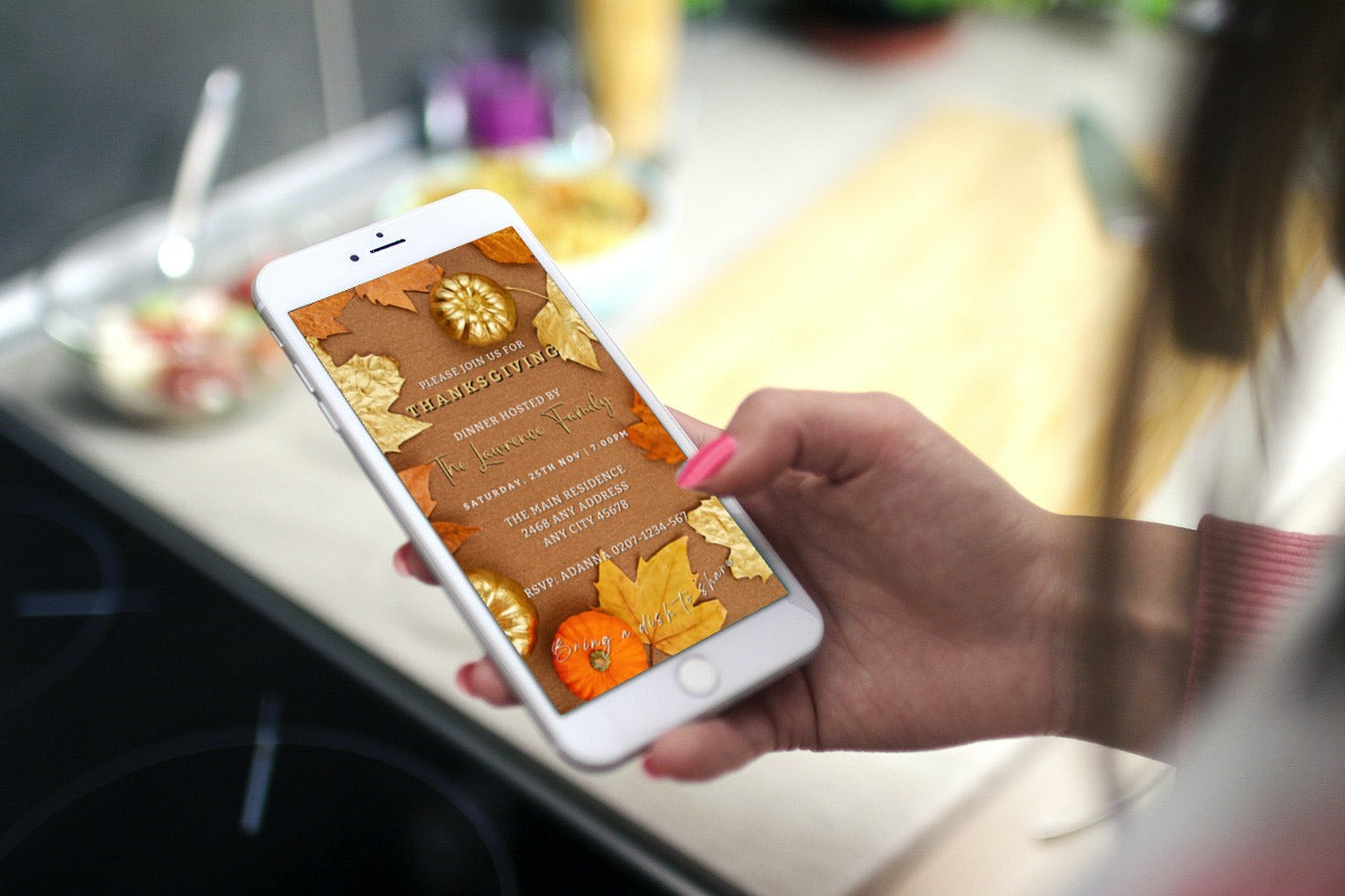 Hand holding a cell phone displaying the Beige Gold Leaves Pumpkin | Thanksgiving Evite, customizable via Canva for digital invitations.