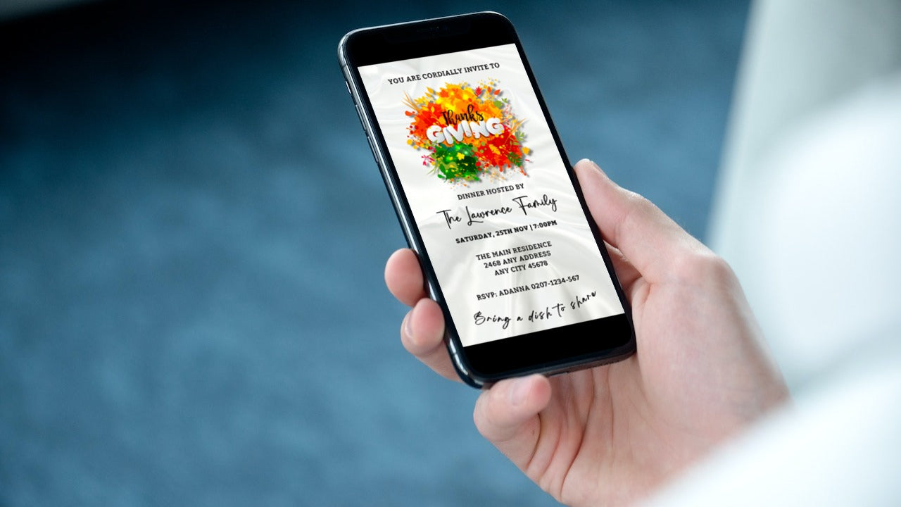 Hand holding a smartphone displaying a Thanksgiving dinner invitation with a colorful white silk background.