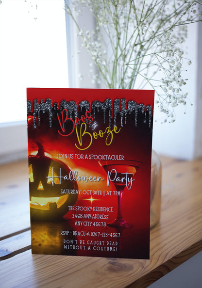 BOOS & BOOZE RED HOT PUMPKIN | HALLOWEEN EVITE displayed on a wooden table, featuring customizable Halloween party invitation templates with a pumpkin and drink illustration.