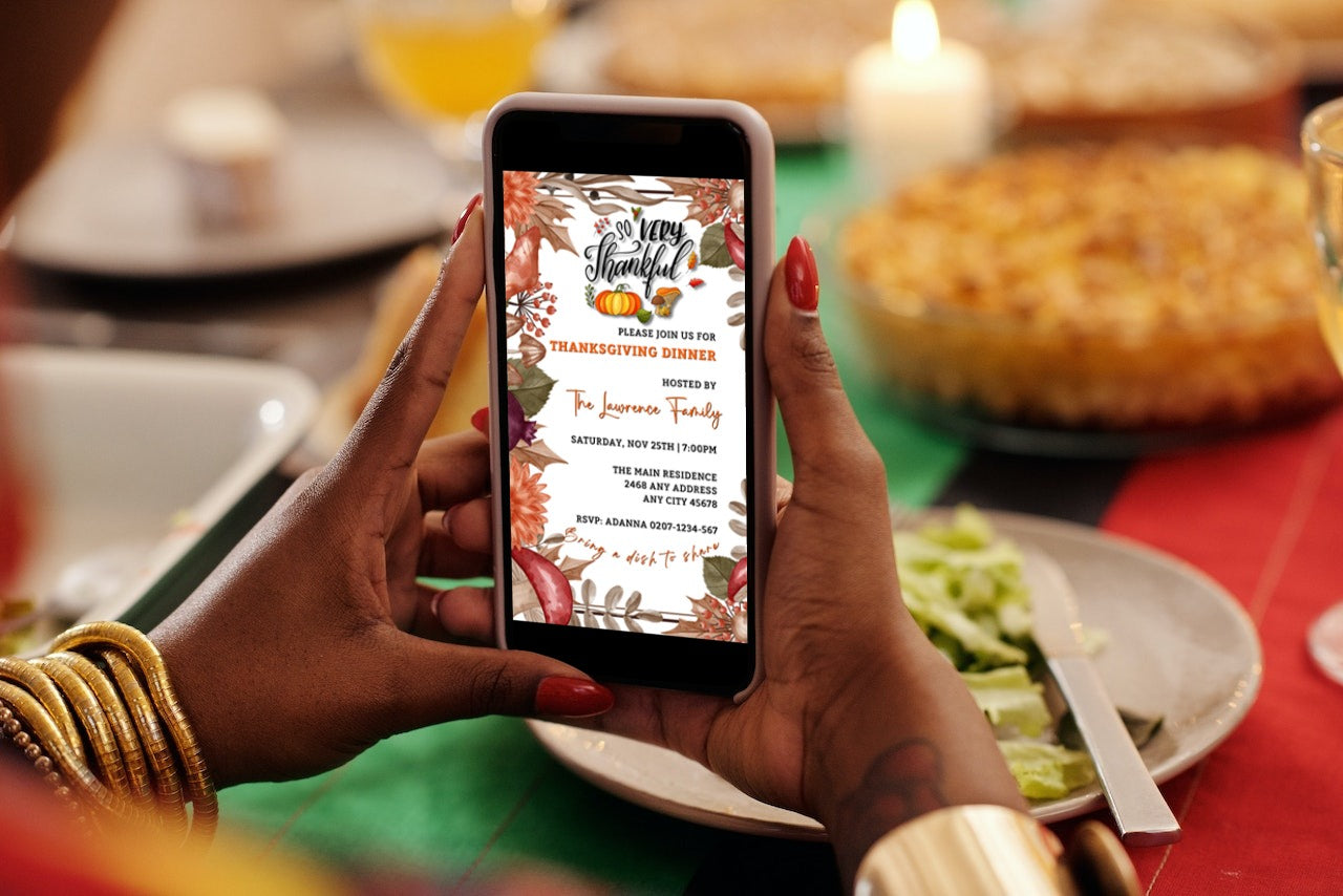 Person holding a smartphone displaying an editable digital Thanksgiving Dinner invitation from URCordiallyInvited, featuring autumn leaves design, customizable via Canva.
