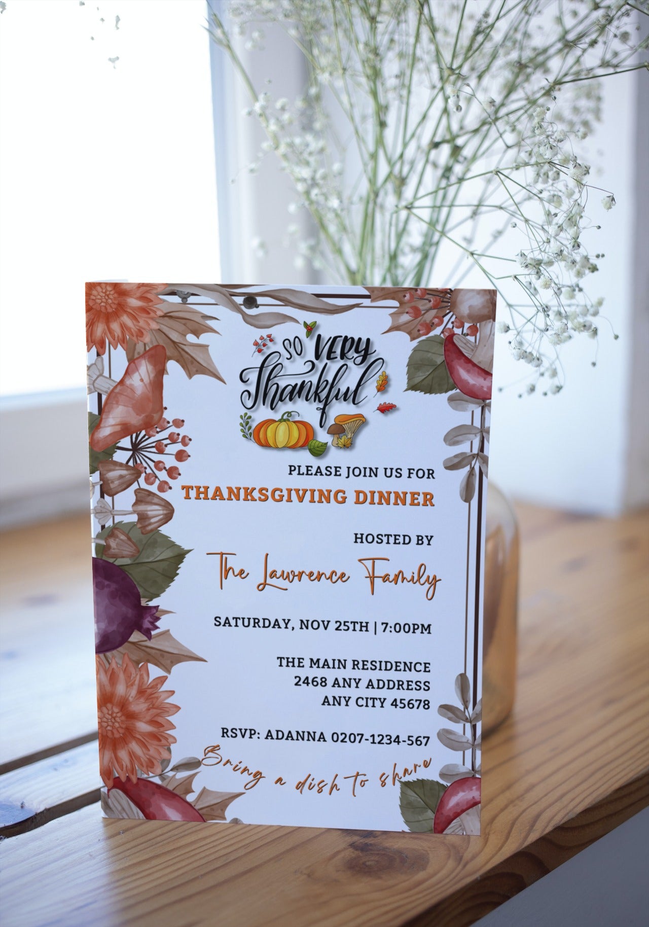 Autumn Leaves Themed Thanksgiving Dinner Evite displayed on a wooden surface with flowers and autumn leaves. Customizable digital invitation template for easy personalizing and sharing.