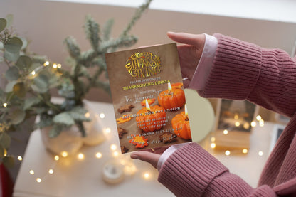 Person holding a Thanksgiving invitation card from the Gold Lit Pumpkins | Thanksgiving Evite, customizable via Canva for electronic sharing.