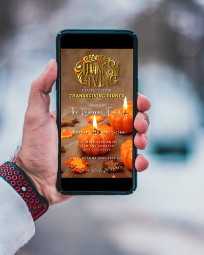 Hand holding a cell phone displaying a customizable Gold Lit Pumpkins Thanksgiving Evite invitation template with a lit candle and pumpkin design.