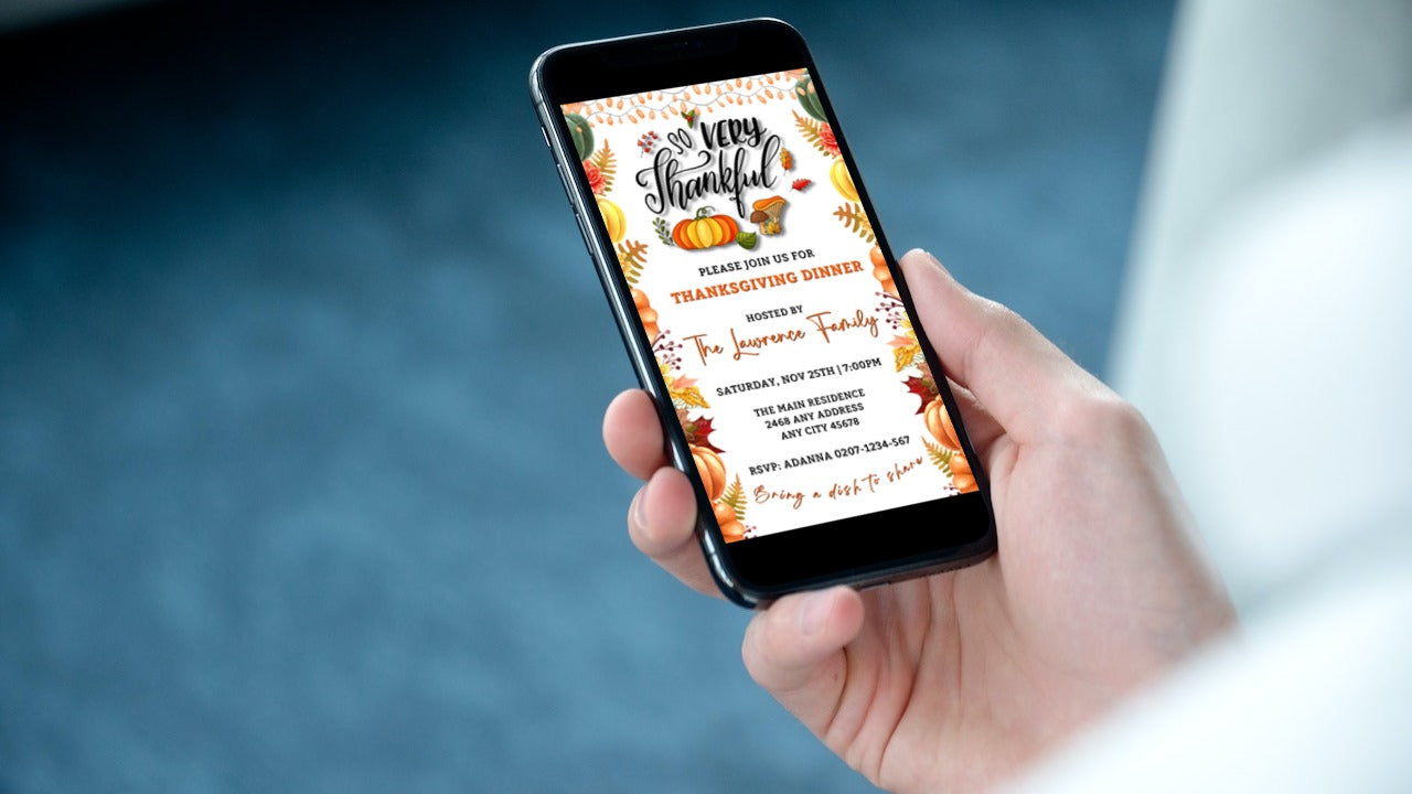 Hand holding a smartphone displaying a Colourful Fall Leaves Pumpkins | Thanksgiving Evite invitation template.