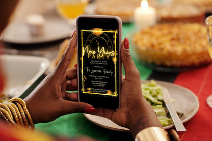 Person holding a smartphone displaying a Roman Clock Golden Frame New Years Party Evite invitation template.