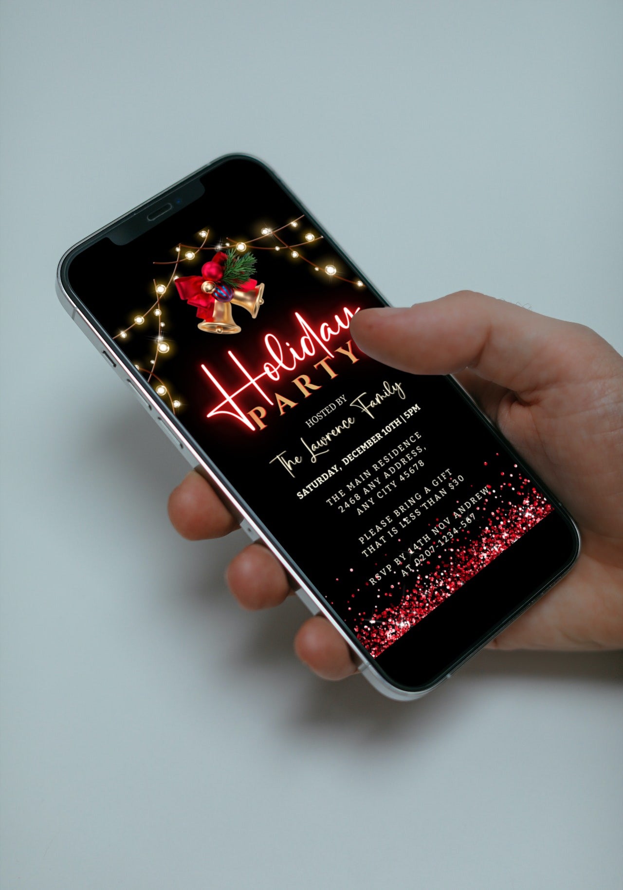 A hand holding a smartphone displaying a customizable Gold Bell Red Neon Holiday Party Evite template.