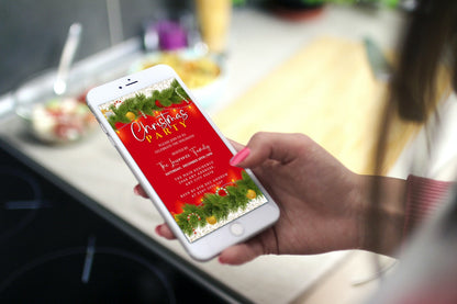 Hand holding a smartphone displaying a customizable Christmas Party Evite with red, green, and white ornaments lights design from URCordiallyInvited.