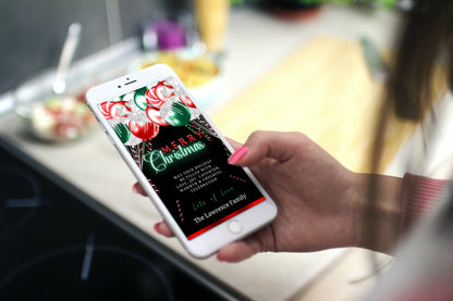 Person holding a smartphone displaying a digital Red Neon Green Balloons Merry Christmas Ecard template for customization.