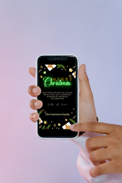 A hand holding a smartphone displaying the Green Neon Ornaments & Presents Merry Christmas Ecard template from URCordiallyInvited.