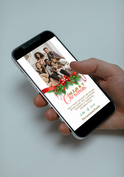 Hand holding a smartphone displaying an Editable Digital Red Bow Ornament Merry Christmas Greeting Ecard from URCordiallyInvited.