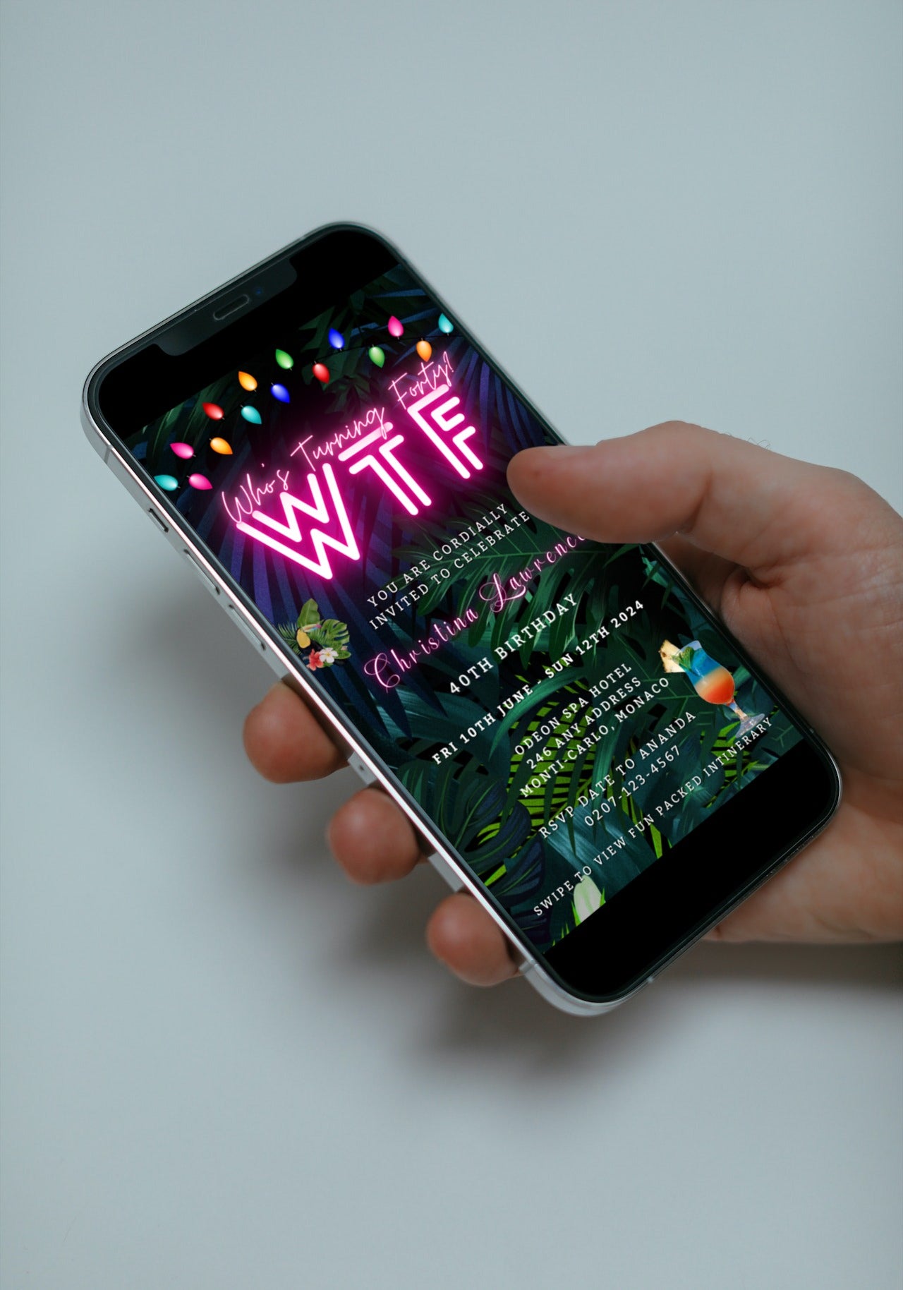 A hand holding a smartphone displaying a customizable Tropical Destination Neon Pink Who's Turning Fifty Weekend Evite template.