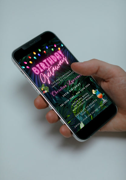 A hand holding a smartphone displaying a customizable Tropical Destination Neon Pink | Birthday Getaway Evite template.