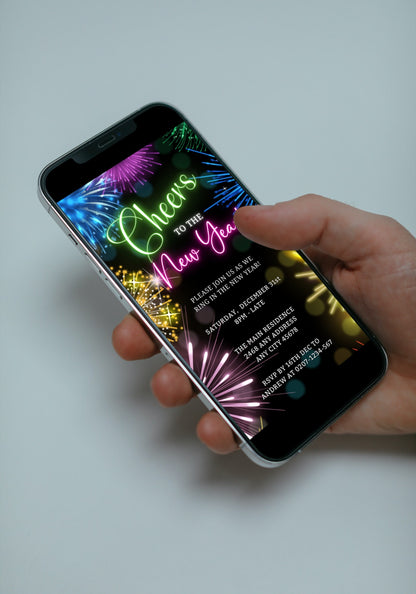 Hand holding a smartphone displaying a customizable Neon Pink Green Fireworks New Year's Eve Party Evite template from URCordiallyInvited.