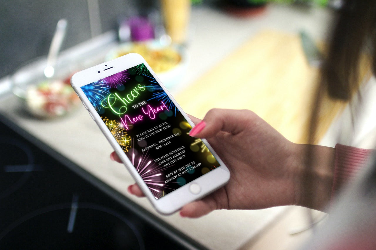 Hand holding a smartphone displaying the Neon Pink Green Fireworks New Years Eve Party Evite, a customizable digital invitation template from URCordiallyInvited.