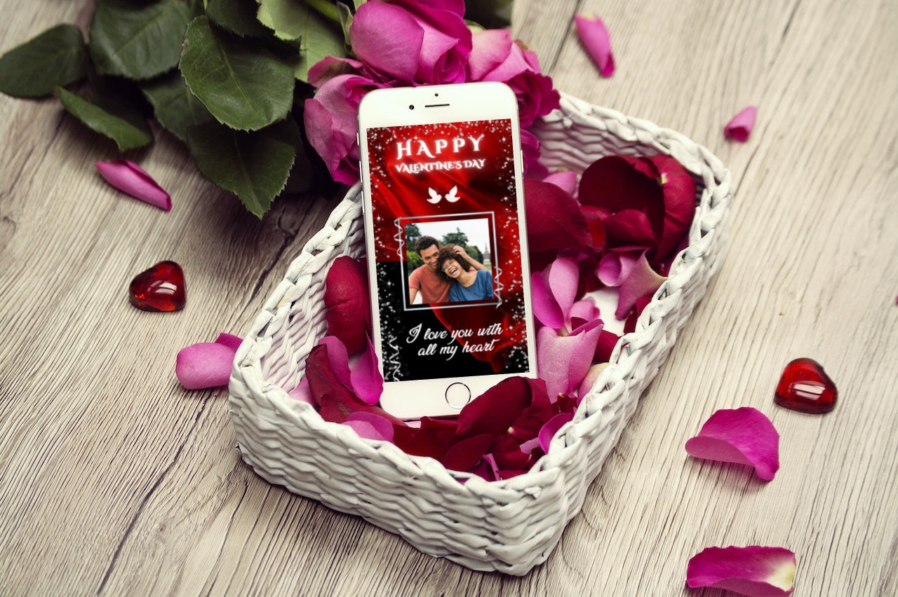 Cellphone on a basket of rose petals showcasing Red Flowing Fabric Valentine's eCard template for easy customization via Canva.