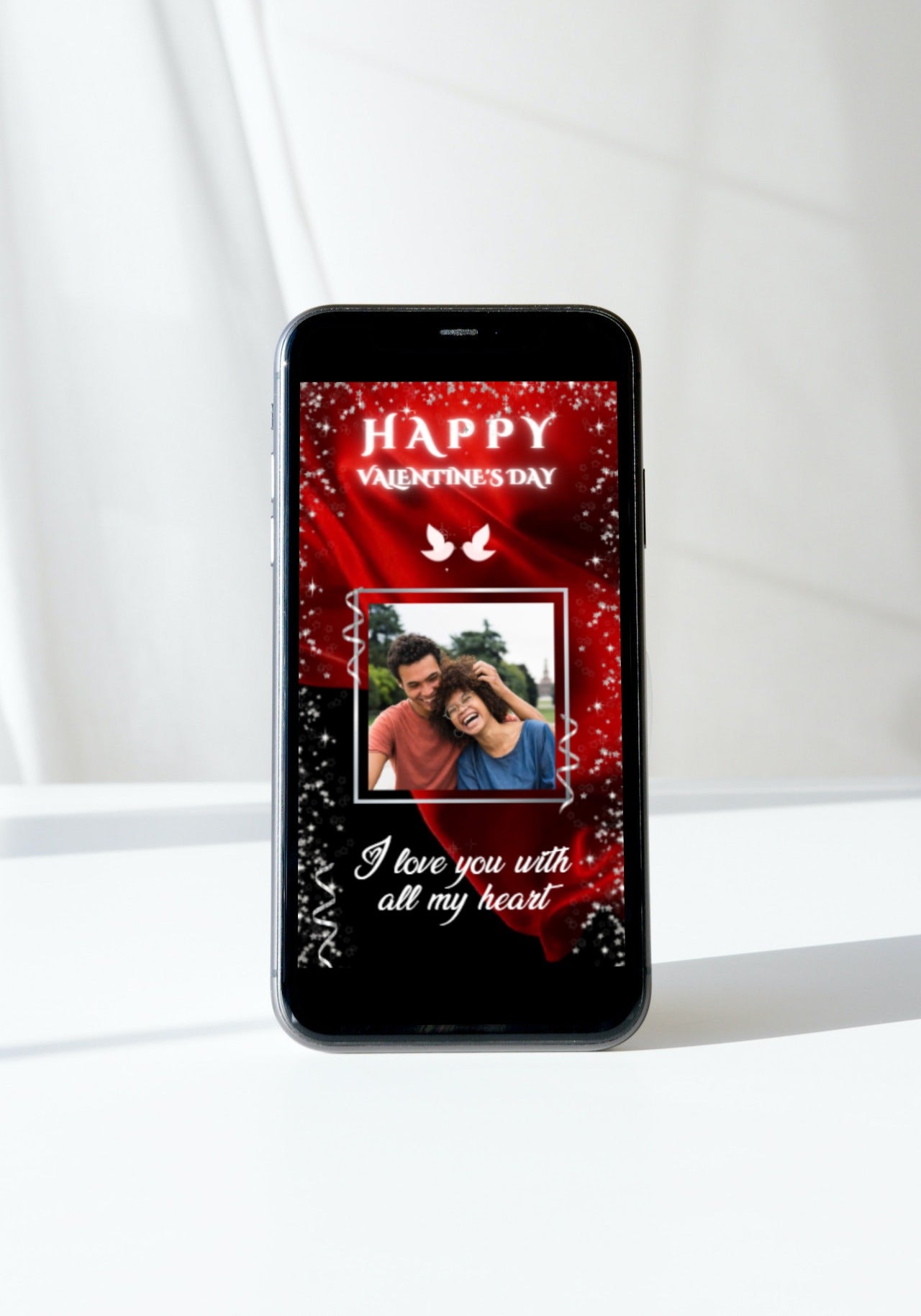Smartphone displaying a customizable Valentine's ecard with a red flowing fabric background, featuring a laughing man and woman.