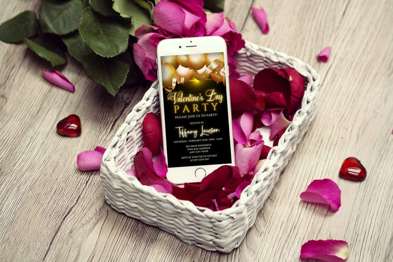 Black Gold Neon Balloons Valentines Day Party Evite displayed on a smartphone, nestled in a basket of rose petals.