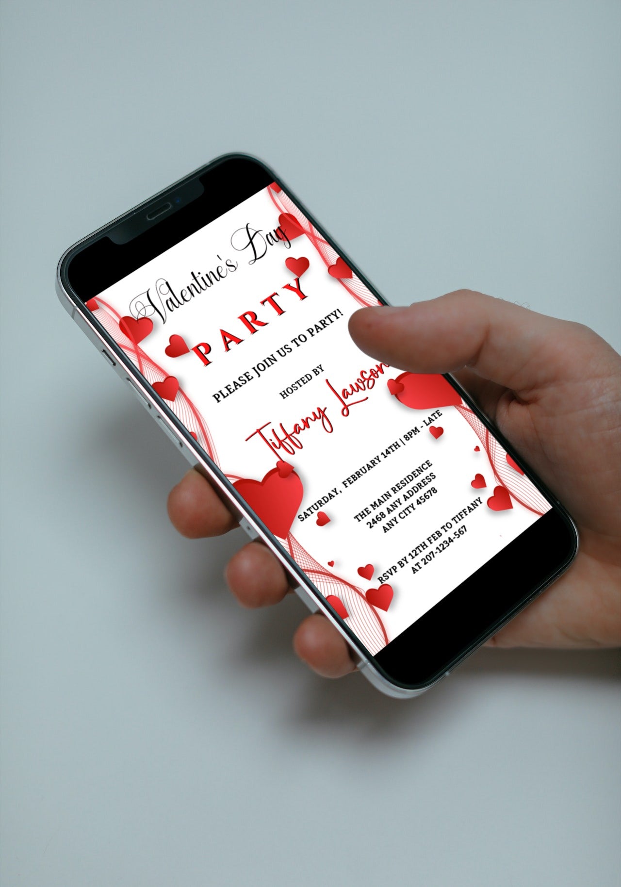 Hand holding a smartphone displaying the Editable Digital White Red Border Hearts Valentine's Party Evite template from URCordiallyInvited.