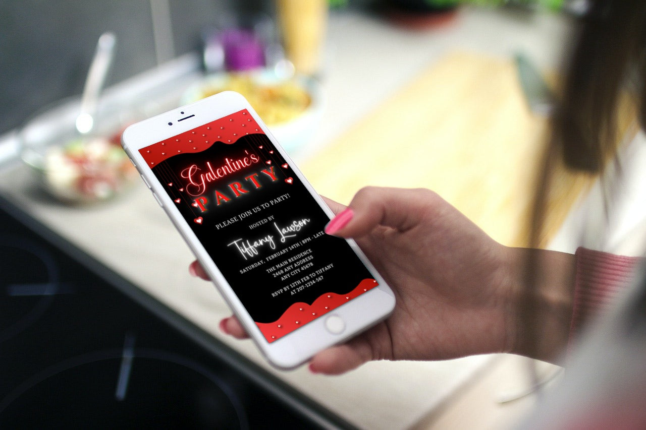 Hand holding a phone displaying Diamond Red Hearts Border Galentine's Party Evite template from URCordiallyInvited, customizable via Canva for easy electronic sharing.