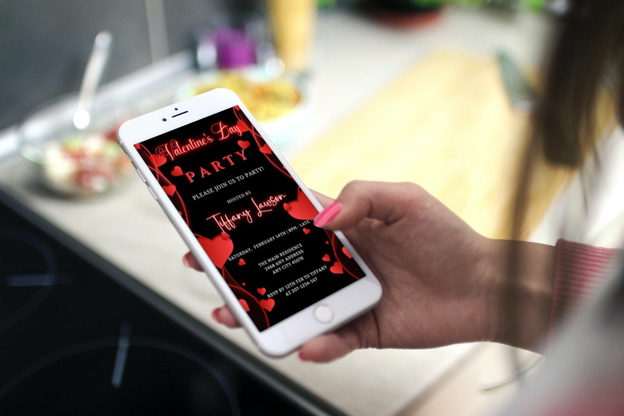 Hand holding smartphone displaying Black Neon Red Border Hearts Valentines Party Evite, customizable template for digital invitations via Canva.