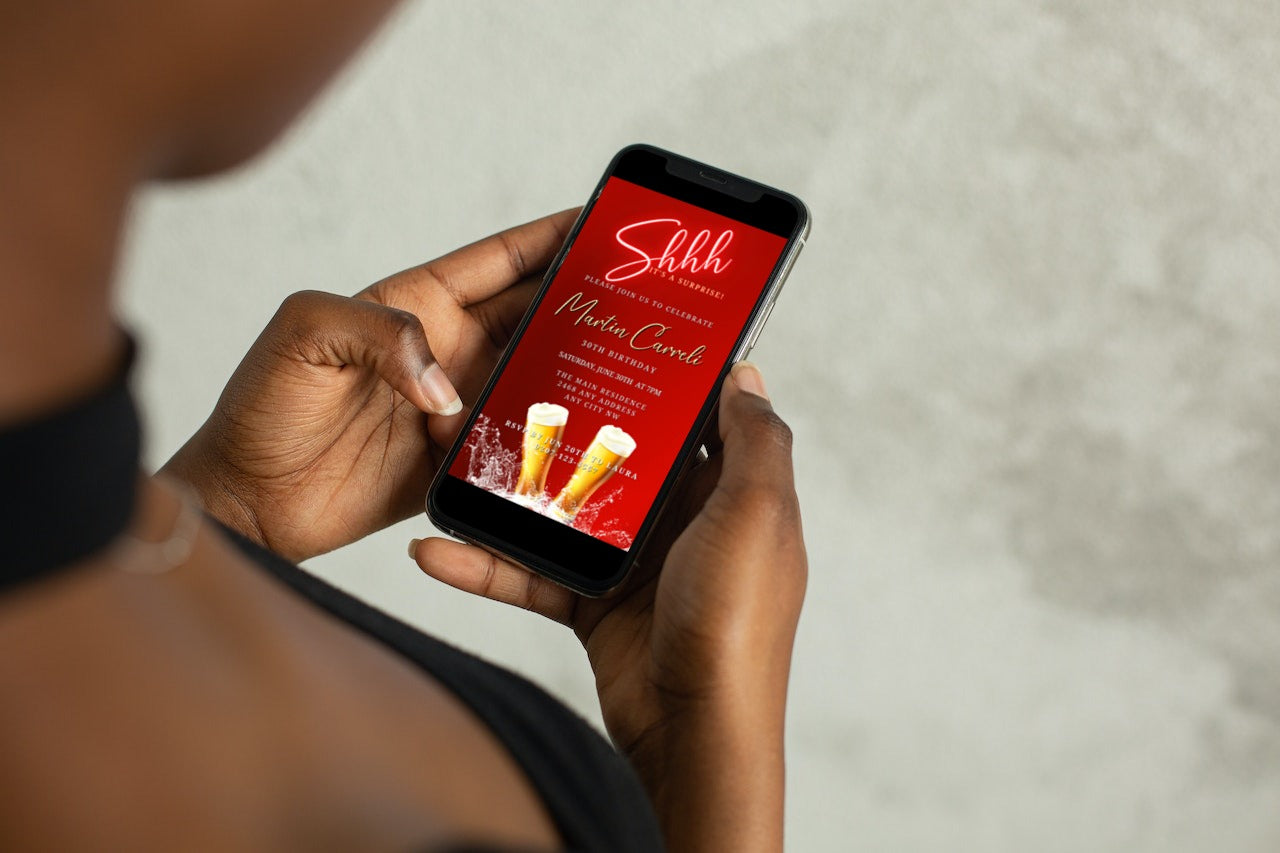 Person holding a smartphone displaying a customizable Men's Red Neon Beer Splash Surprise Birthday Evite, downloadable and editable via Canva for electronic invitations.