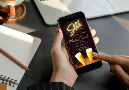 A person holding a phone displaying the customizable Gold Neon Beer Men's Surprise Party Evite invitation template.