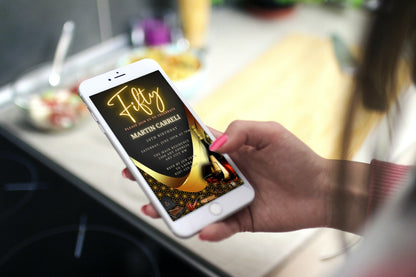 Hand holding a smartphone displaying a customizable digital Black Neon Gold Cigar Men's 50th Birthday Evite from URCordiallyInvited.