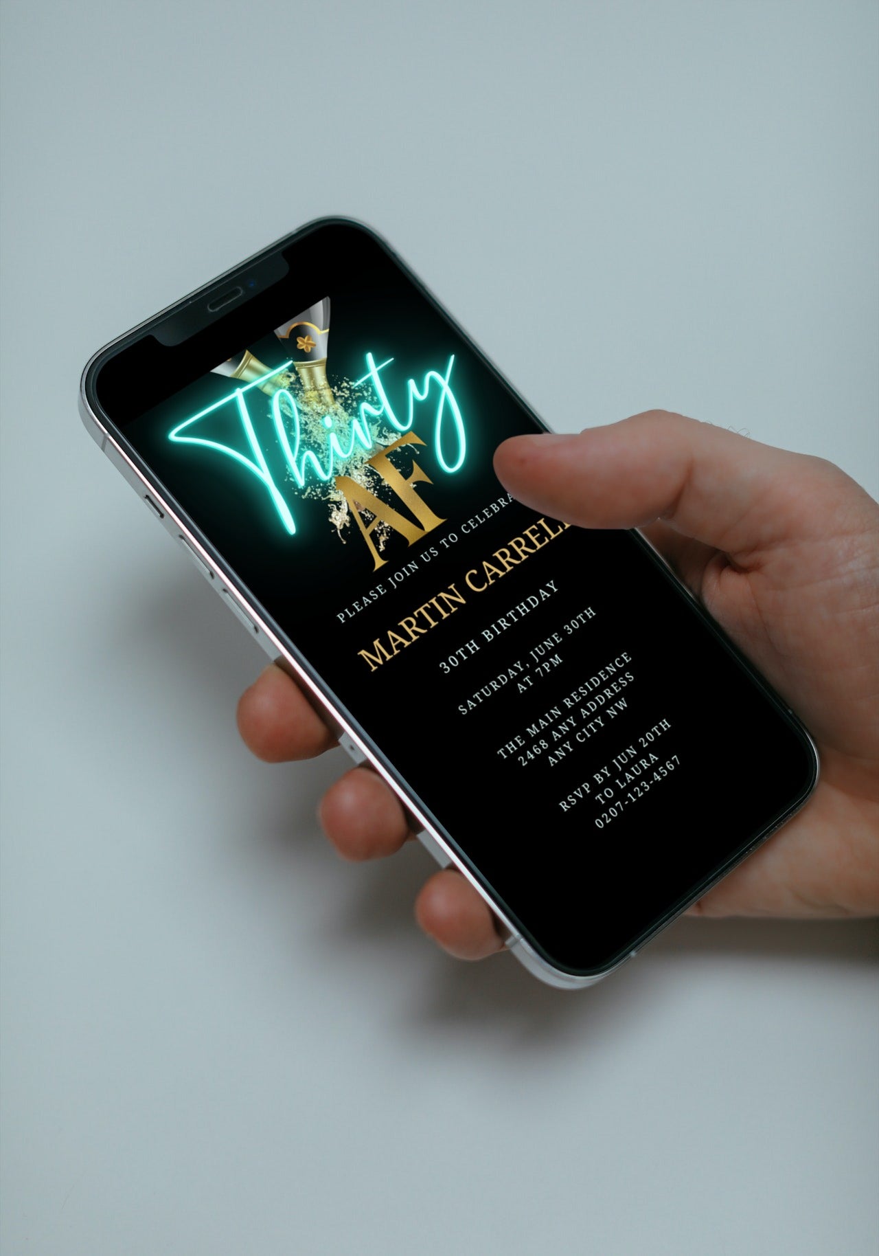 Hand holding a smartphone displaying a customizable Black Gold Champagne Neon Teal | 30AF Party Evite from URCordiallyInvited, shown in a close-up view.