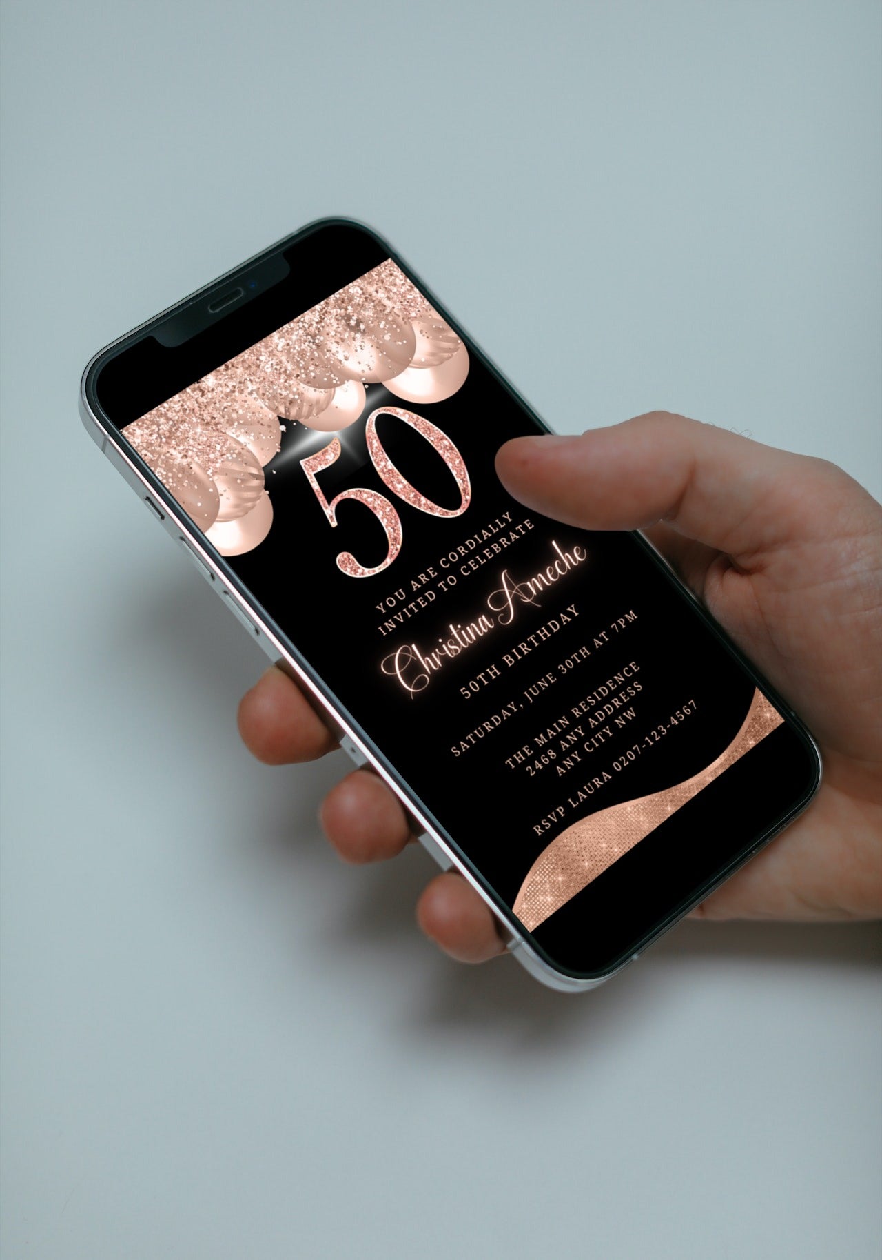 Hand holding a smartphone displaying a customisable Digital Rose Gold Balloons Glitter | 50th Birthday Evite template.