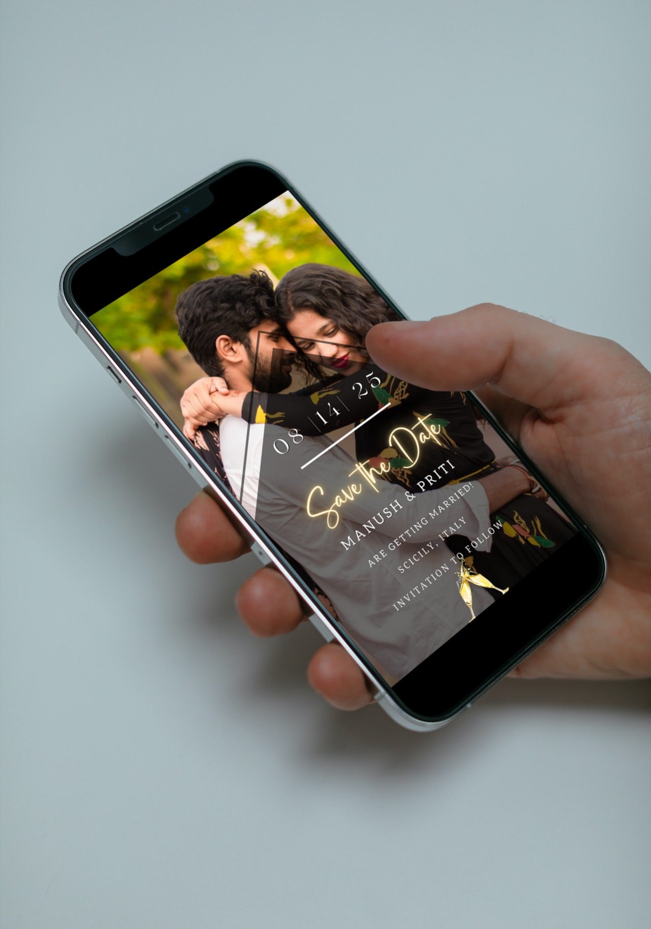 Hand holding a smartphone displaying a couple kissing, representing the Gold Neon Photo | Save The Date Wedding Evite customizable template.