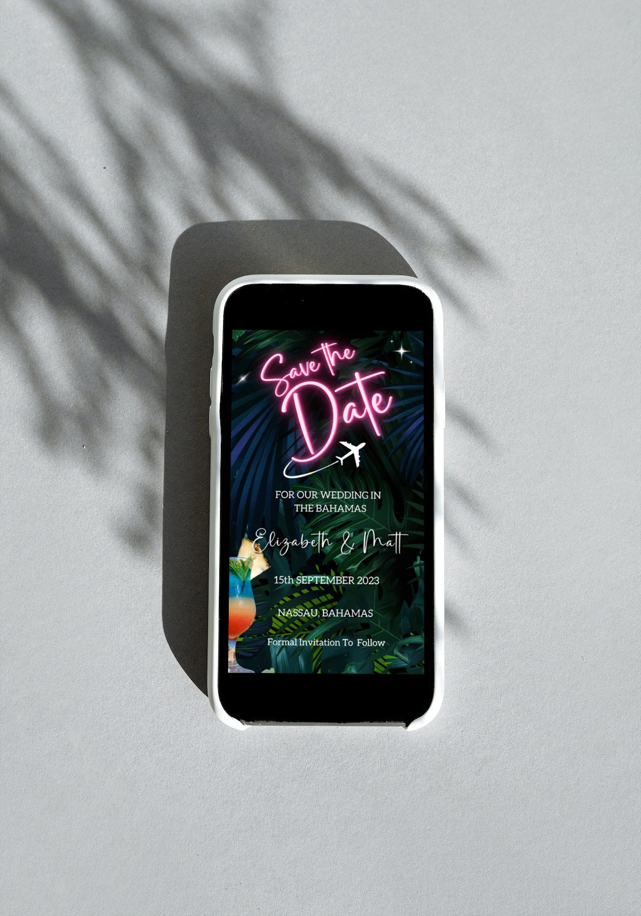 Neon Pink Destination Save The Date Evite displayed on a smartphone screen with a pink neon sign featuring a plane and palm leaves.