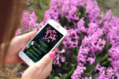 Hand holding a smartphone displaying the Neon Pink Destination | Save The Date Evite template from URCordiallyInvited, ready for customization via Canva.