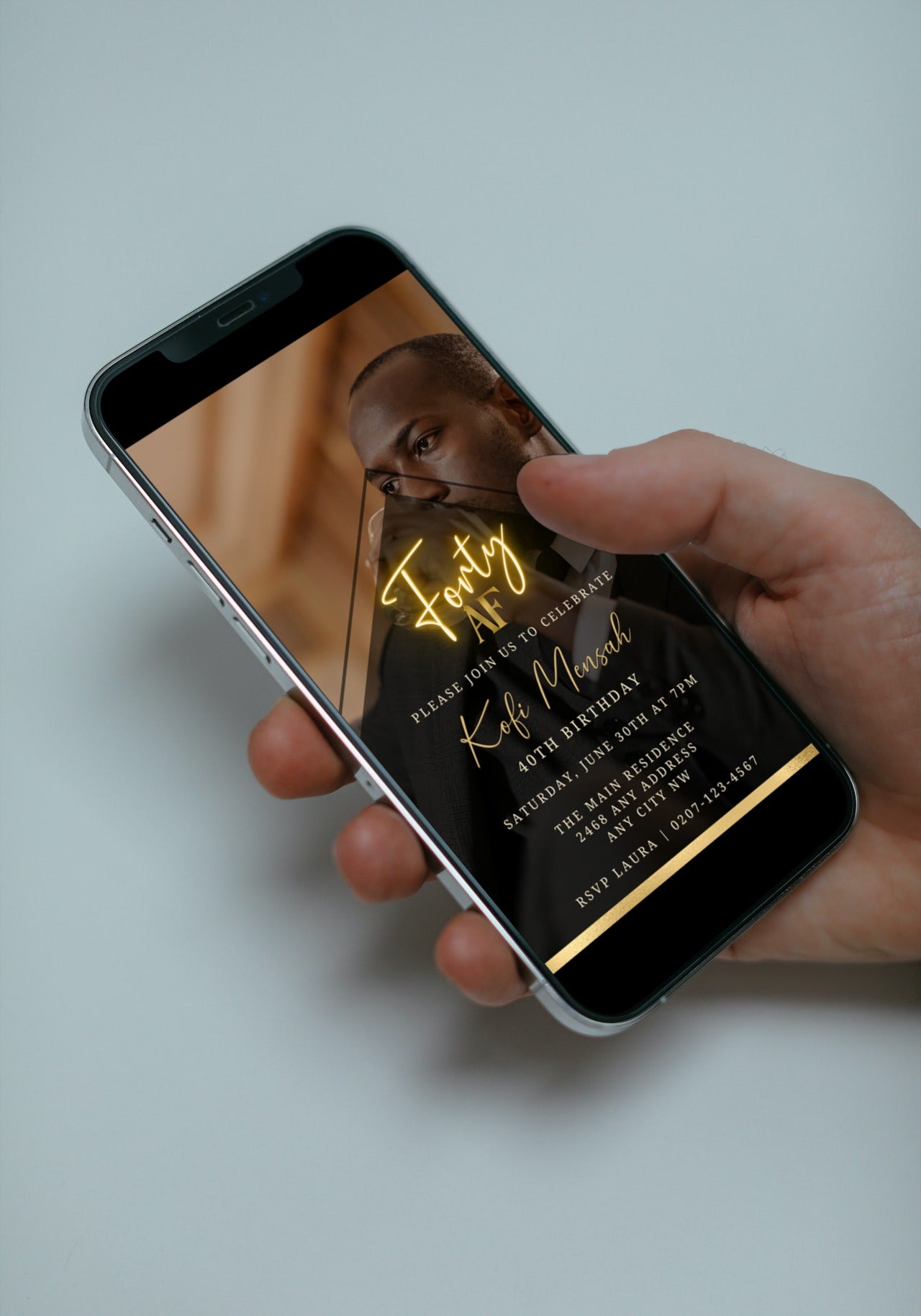 A hand holding a smartphone displaying a customizable Gold Neon Forty AF Party Evite with editable text and photo background.