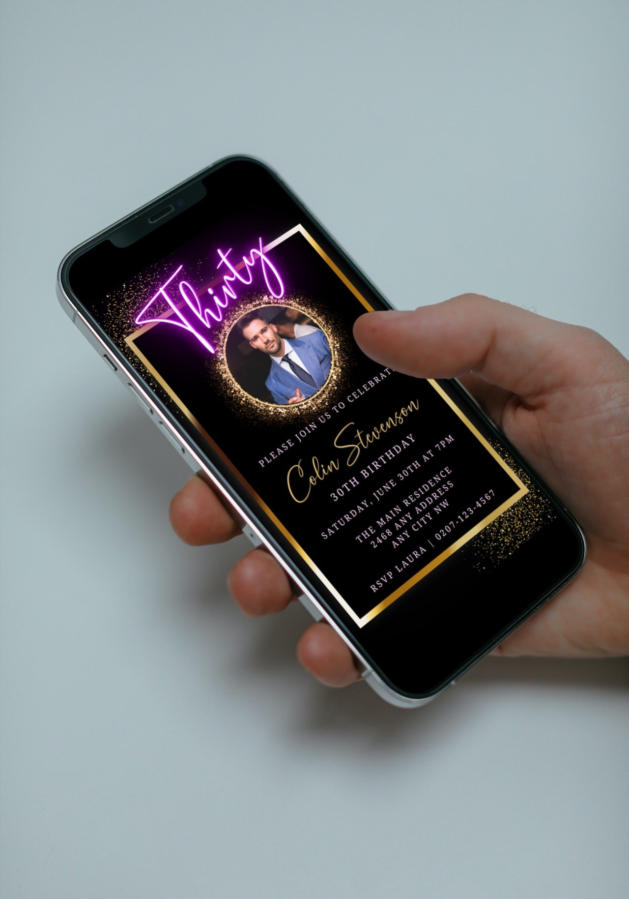 A hand holding a phone displaying a customizable digital 30th party evite with a black and gold neon photo frame.