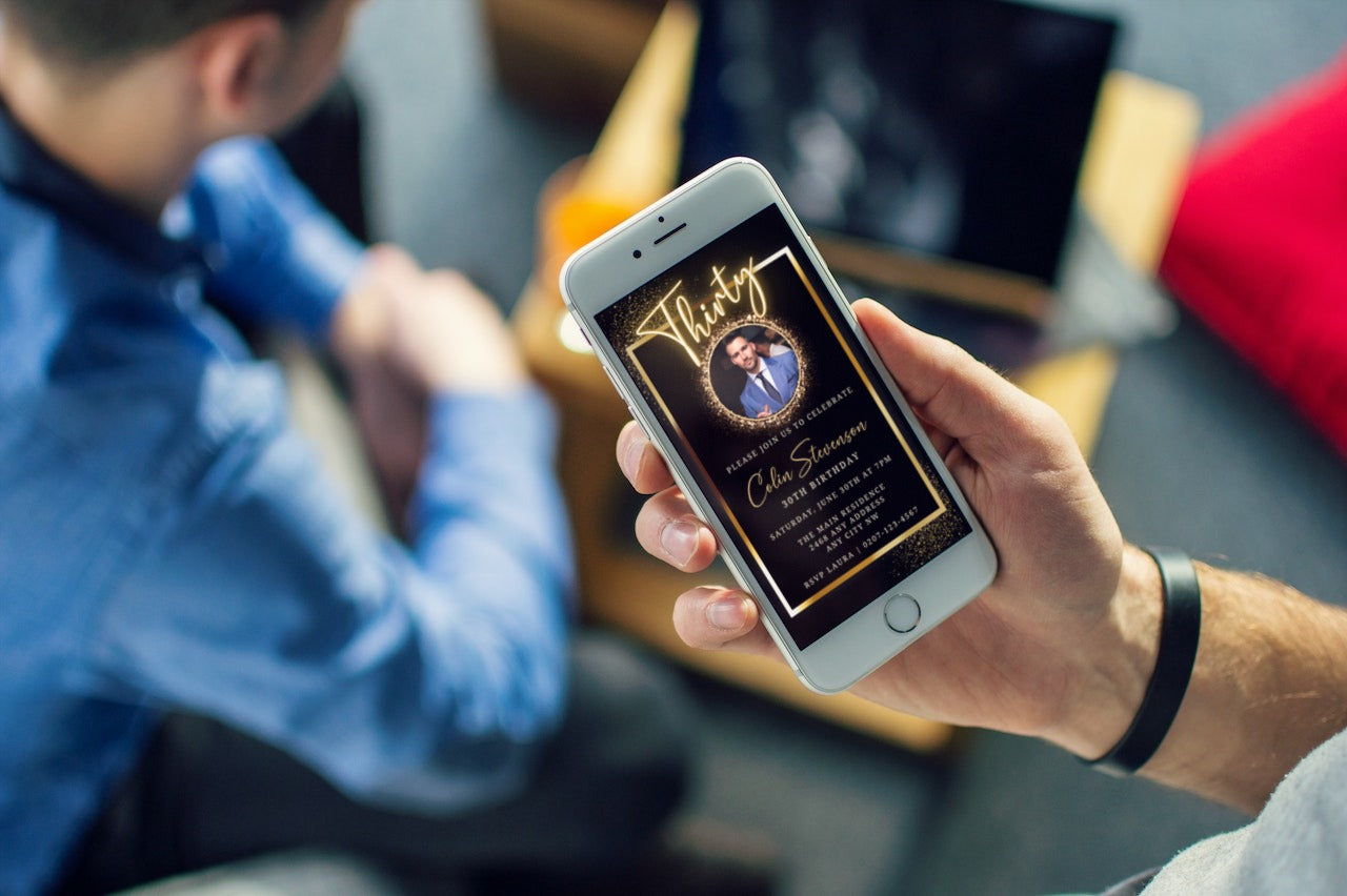 Person holding a phone displaying a customizable Digital Black Gold Neon 30th Party Evite, featuring a photo of a man.