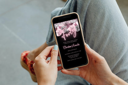 Person holding a phone displaying a customizable Mauve Pink Silver Neon 40AF Birthday Evite from URCordiallyInvited, ready to personalize using Canva.