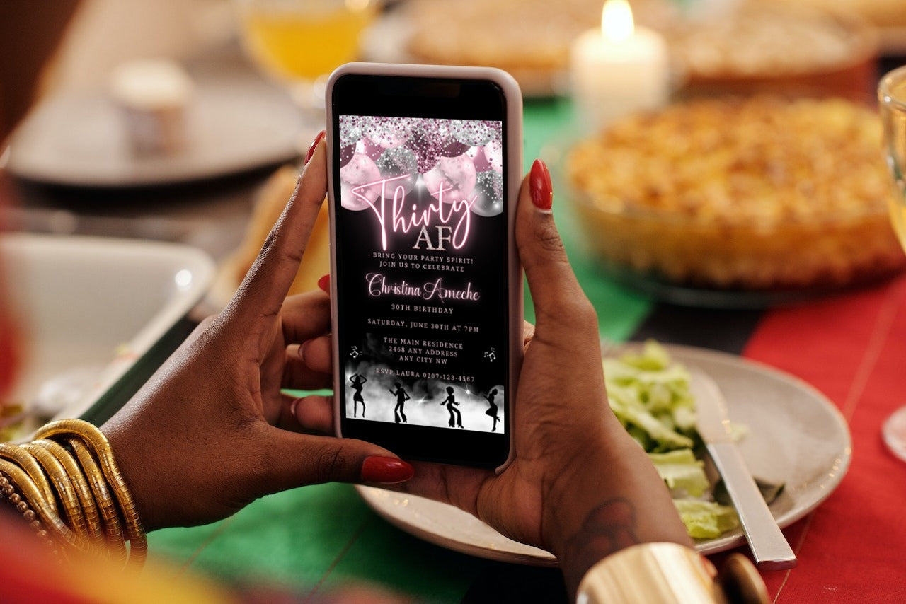 Person holding a phone displaying a customizable Mauve Pink Silver Neon | 30AF Birthday Evite template, ready for personalization via Canva.