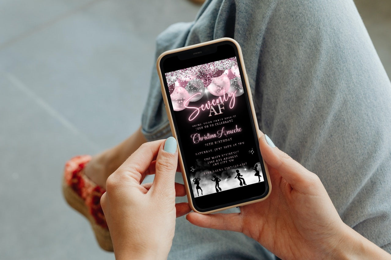 Person holding a smartphone displaying a customizable Mauve Pink Silver Neon 70AF Birthday Evite for easy editing and digital sharing.