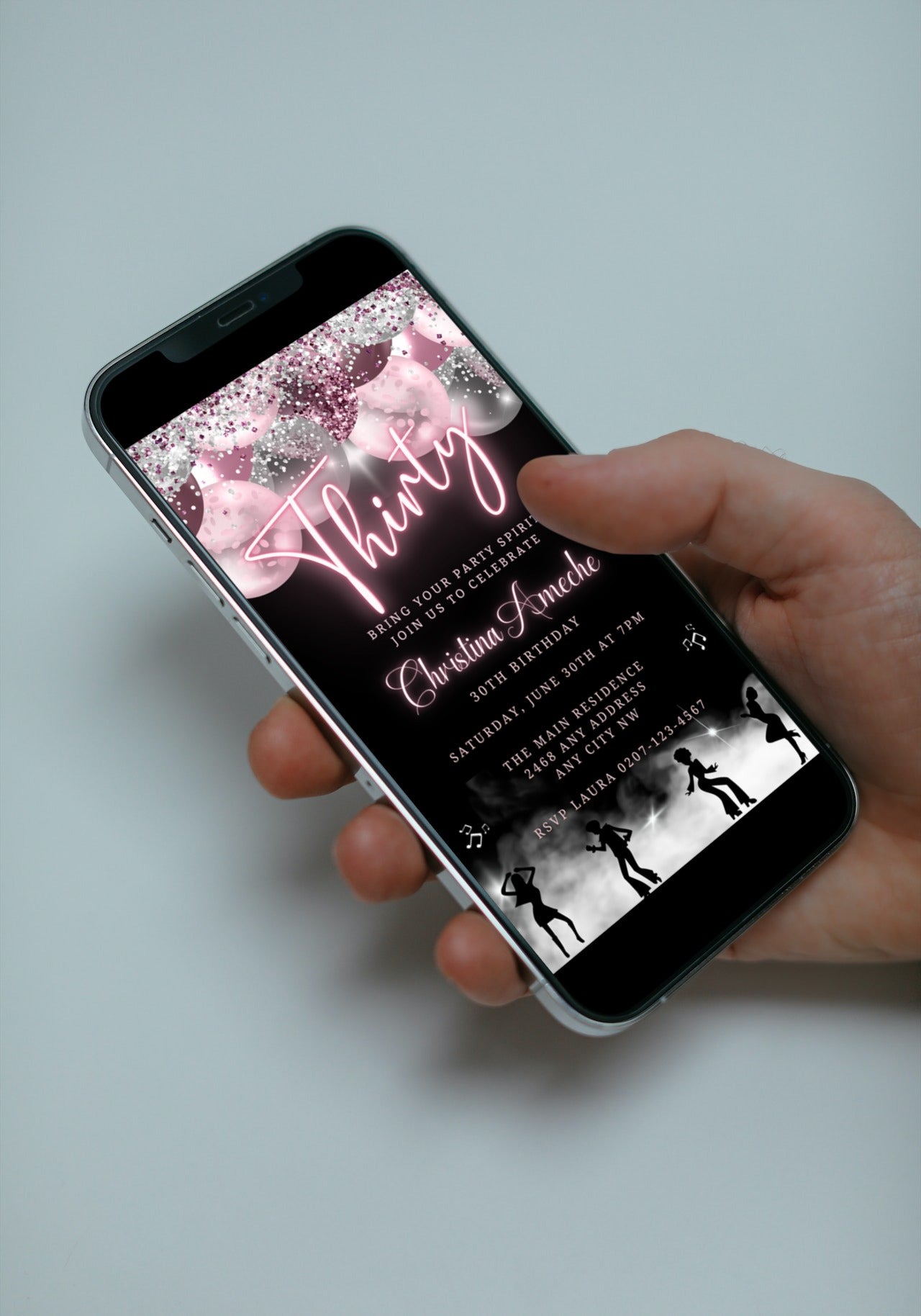 Hand holding a smartphone displaying a customizable Mauve Pink Silver Neon 30AF Birthday Video Evite template for editing and sending via text or email.