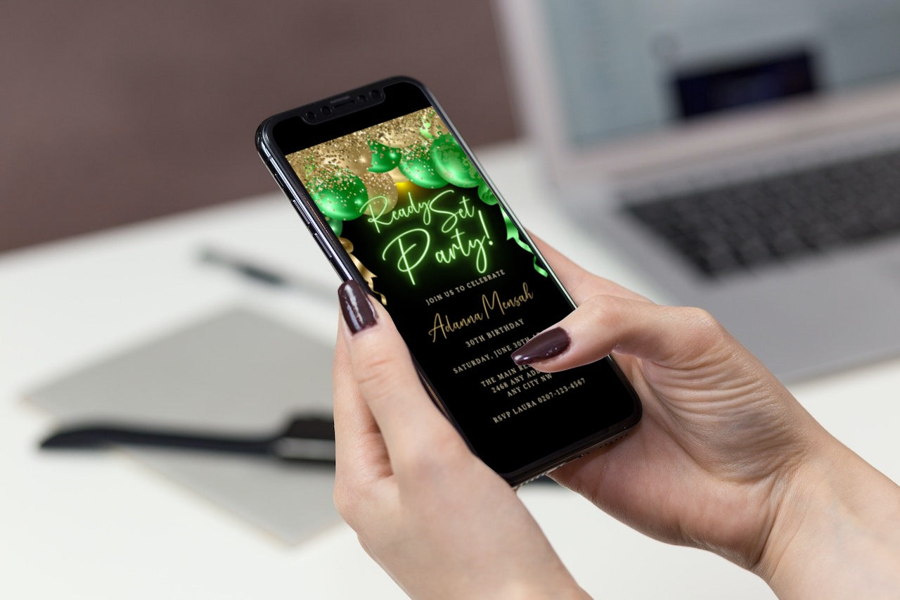 A person holding a smartphone displaying a customizable Gold Green Neon Balloons Birthday Party Evite template.