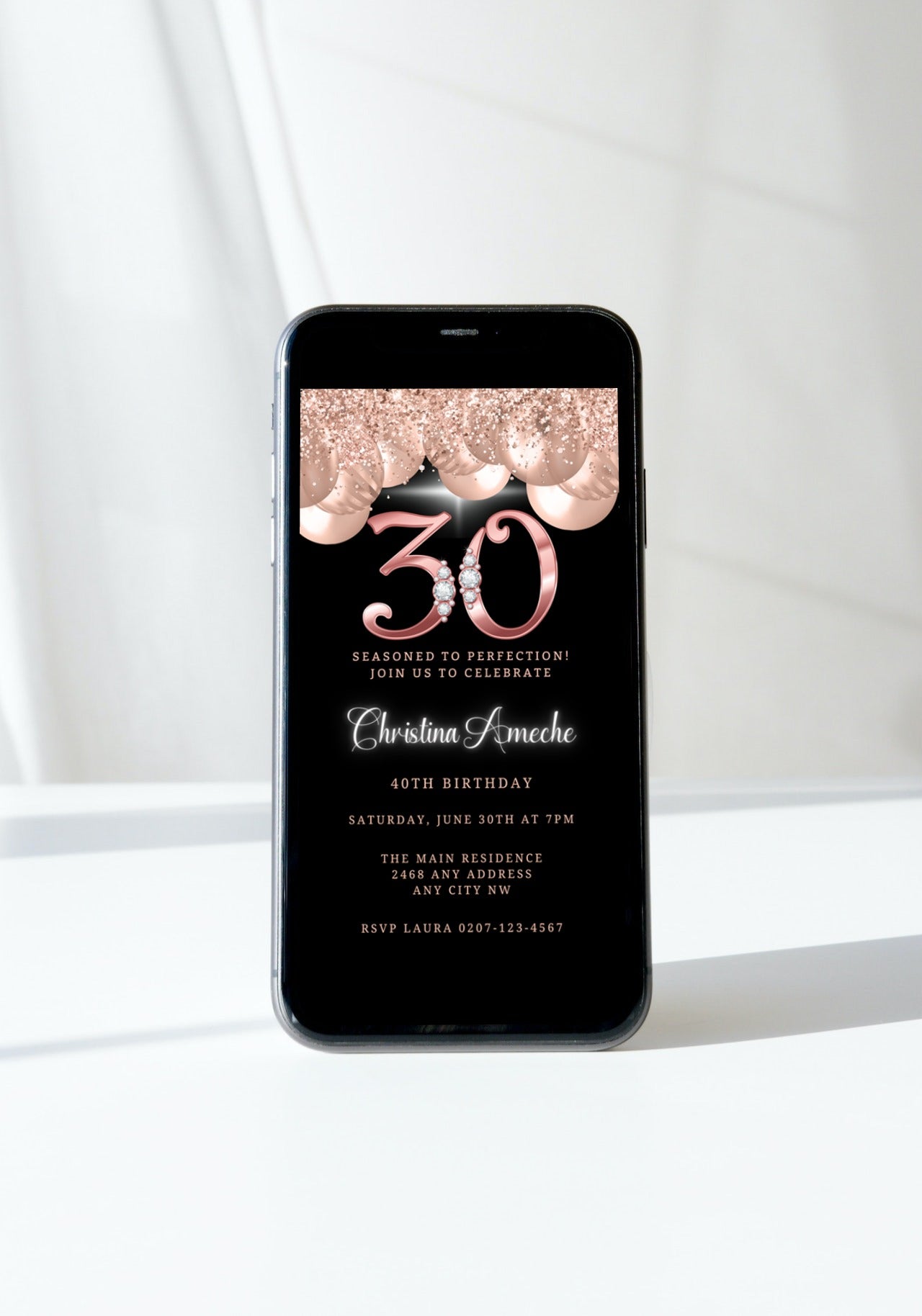 30th Birthday Evite template with rose gold balloons and diamond studs displayed on a smartphone screen, customizable via Canva.