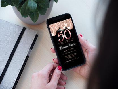 Person holding a smartphone displaying the customisable Rose Gold Balloons Diamond Studs | 50th Birthday Evite template.