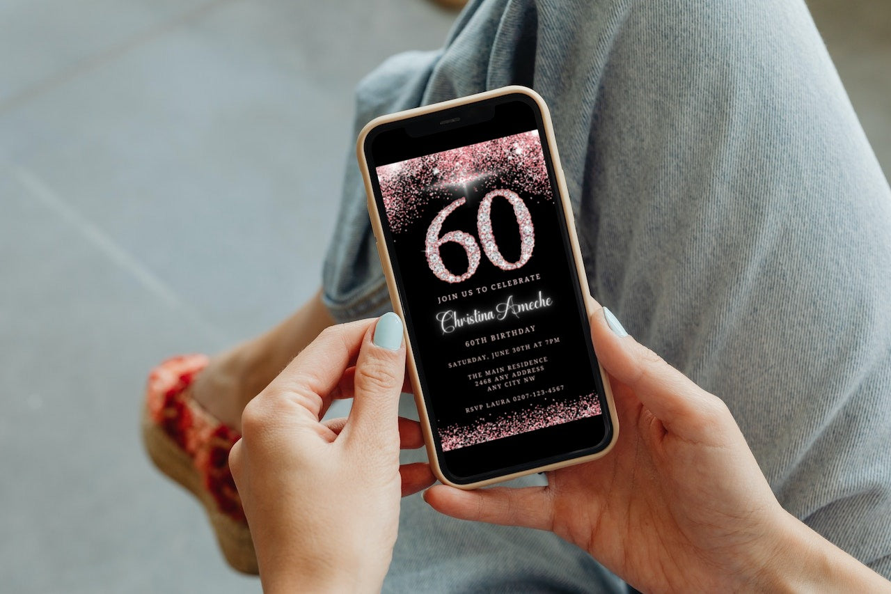 Person holding a smartphone displaying a customizable Rose Gold Diamond Glitter 60th Birthday Evite template for editing and sharing via Canva.