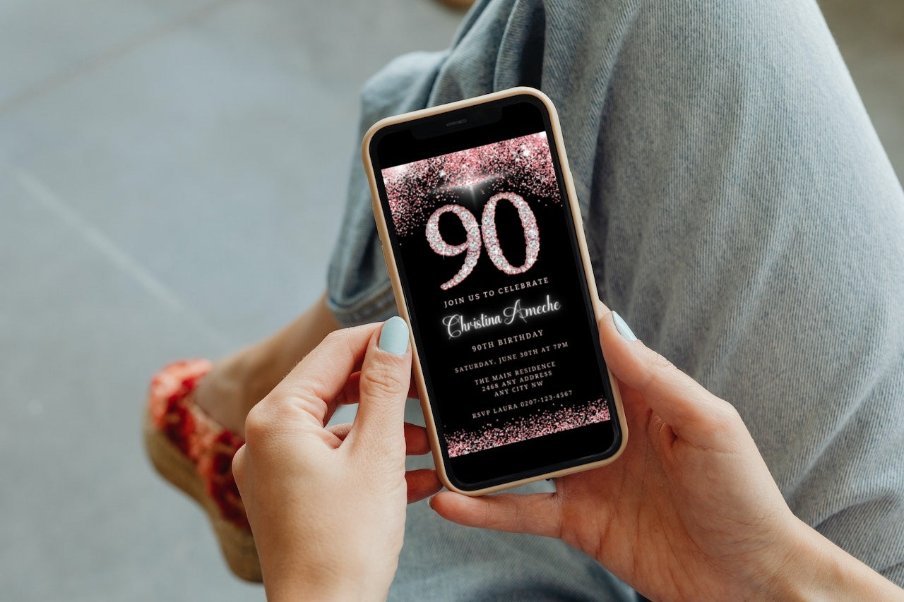 Person holding a phone displaying a customizable Rose Gold Diamond Glitter 90th Birthday Evite for easy personalization and electronic sharing.