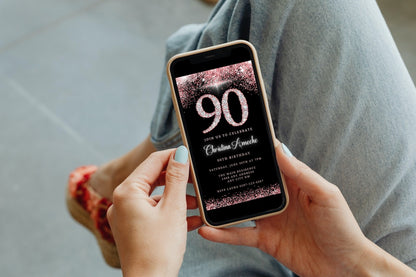 Person holding a phone displaying a customizable Rose Gold Diamond Glitter 90th Birthday Evite for easy personalization and electronic sharing.