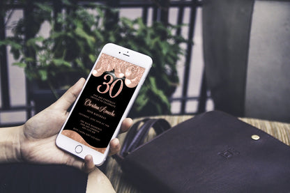 A hand holding a phone displaying a customizable Rose Gold Balloons Glitter 30th Birthday Evite from URCordiallyInvited.